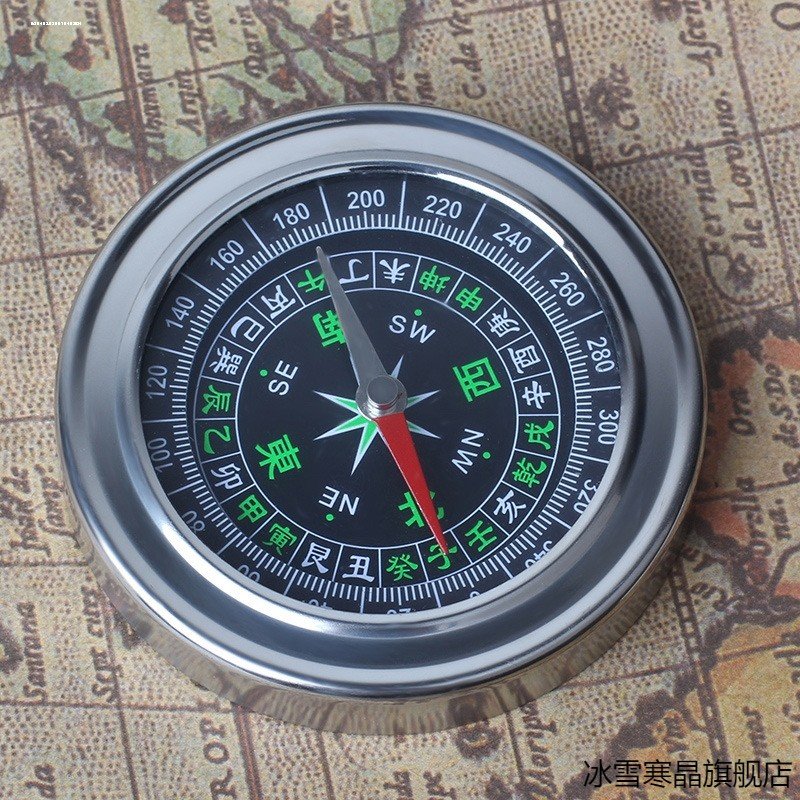 A sports climber with nightlight points to a high-precision outdoor multi-purpose waterproof compass to climb the mountain