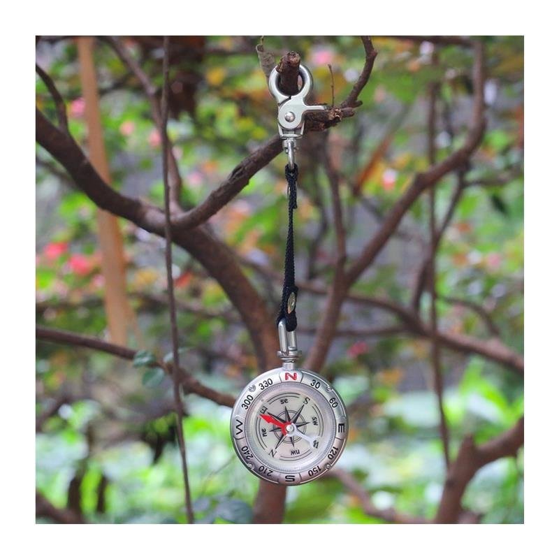 Portable multi-purpose key button guide to an outdoor camping tool compass pointing north to survival
