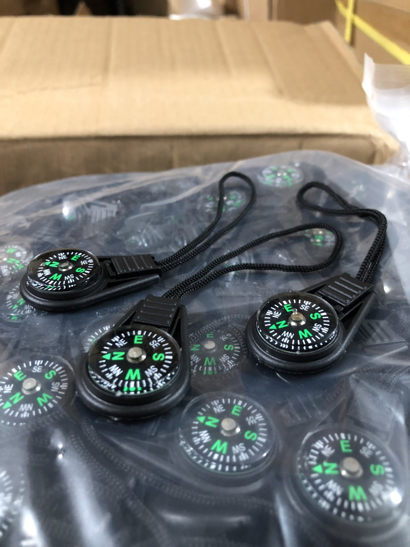 waterproof high-precision of an outdoor 20mm cord compass pointing to a small compass with a key to a knapsack and zipper