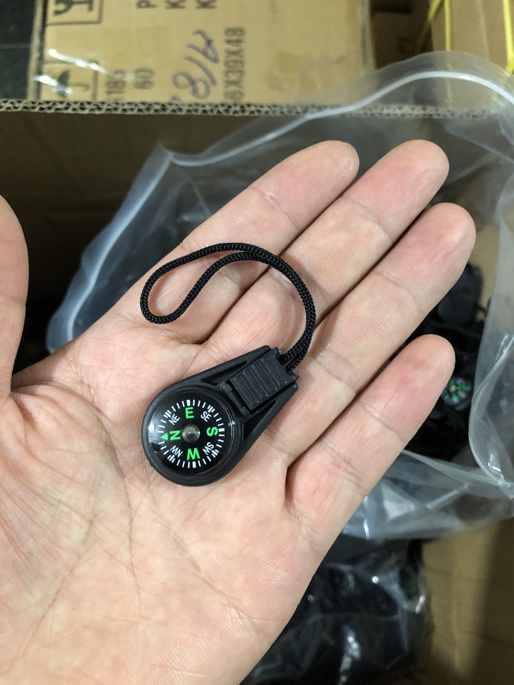waterproof high-precision of an outdoor 20mm cord compass pointing to a small compass with a key to a knapsack and zipper