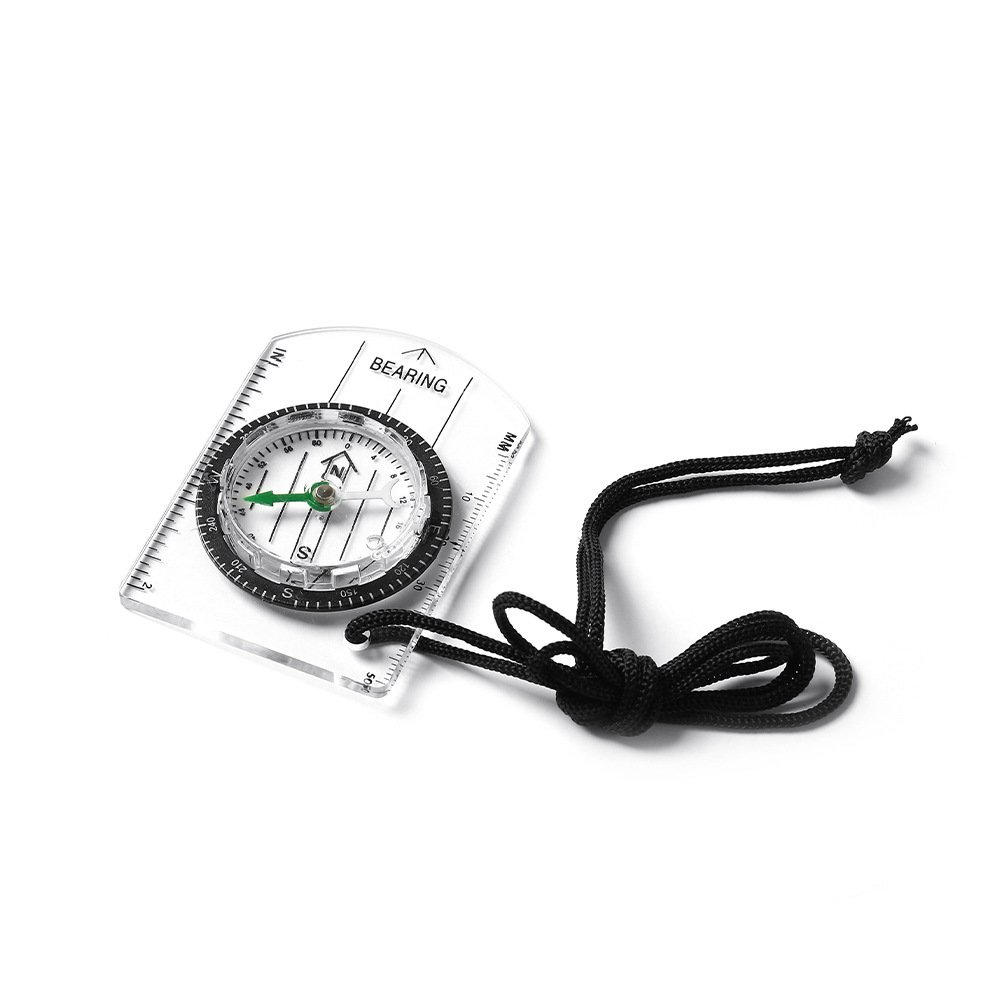 A professional multi-purpose compass for outdoor equipment in the wilderness points to a scale-scale compass of the north map