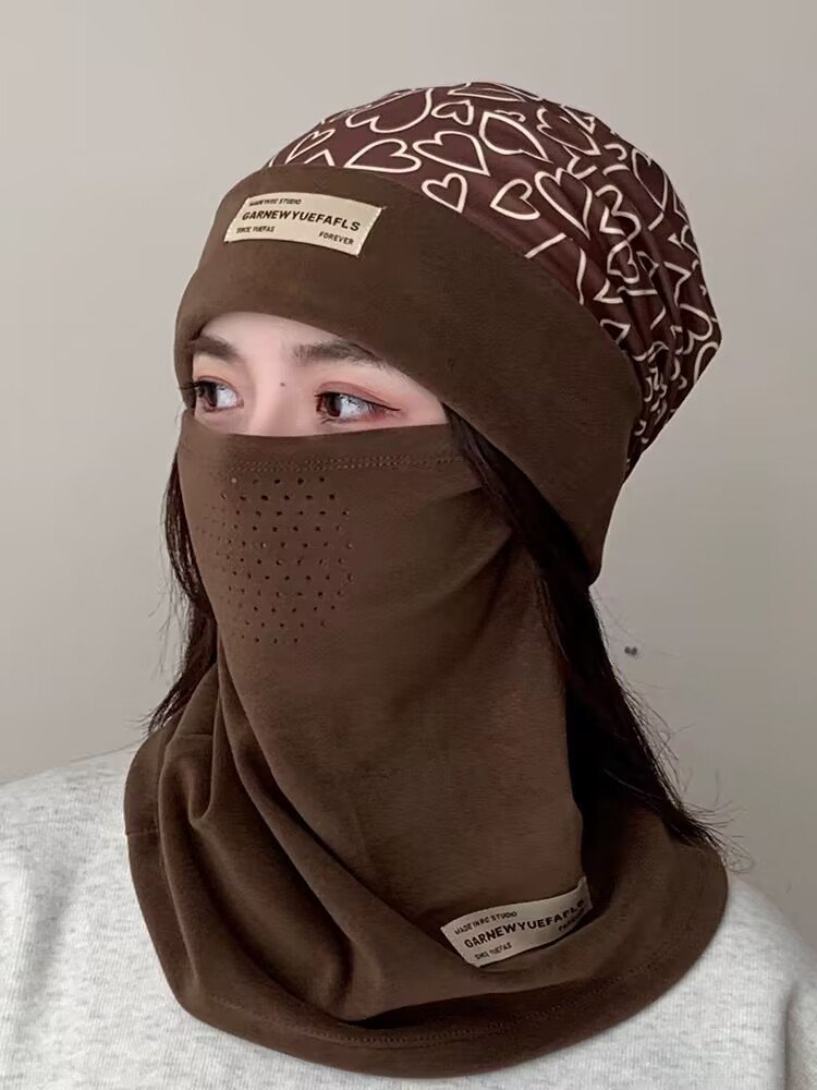 Ski masked woman with a turban with a thick hood on her face in the autumn and winter