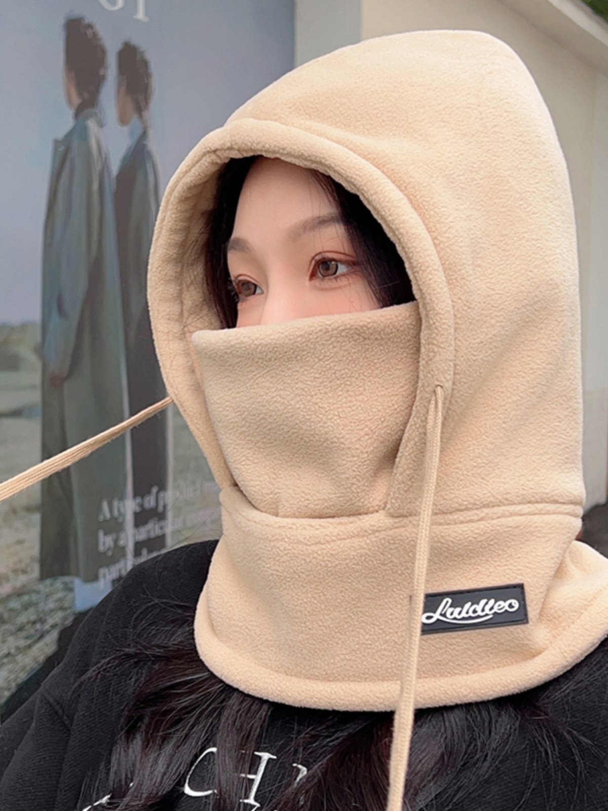 The woman with the hat rides in the winter and winters against the cold and wind-proof hoods