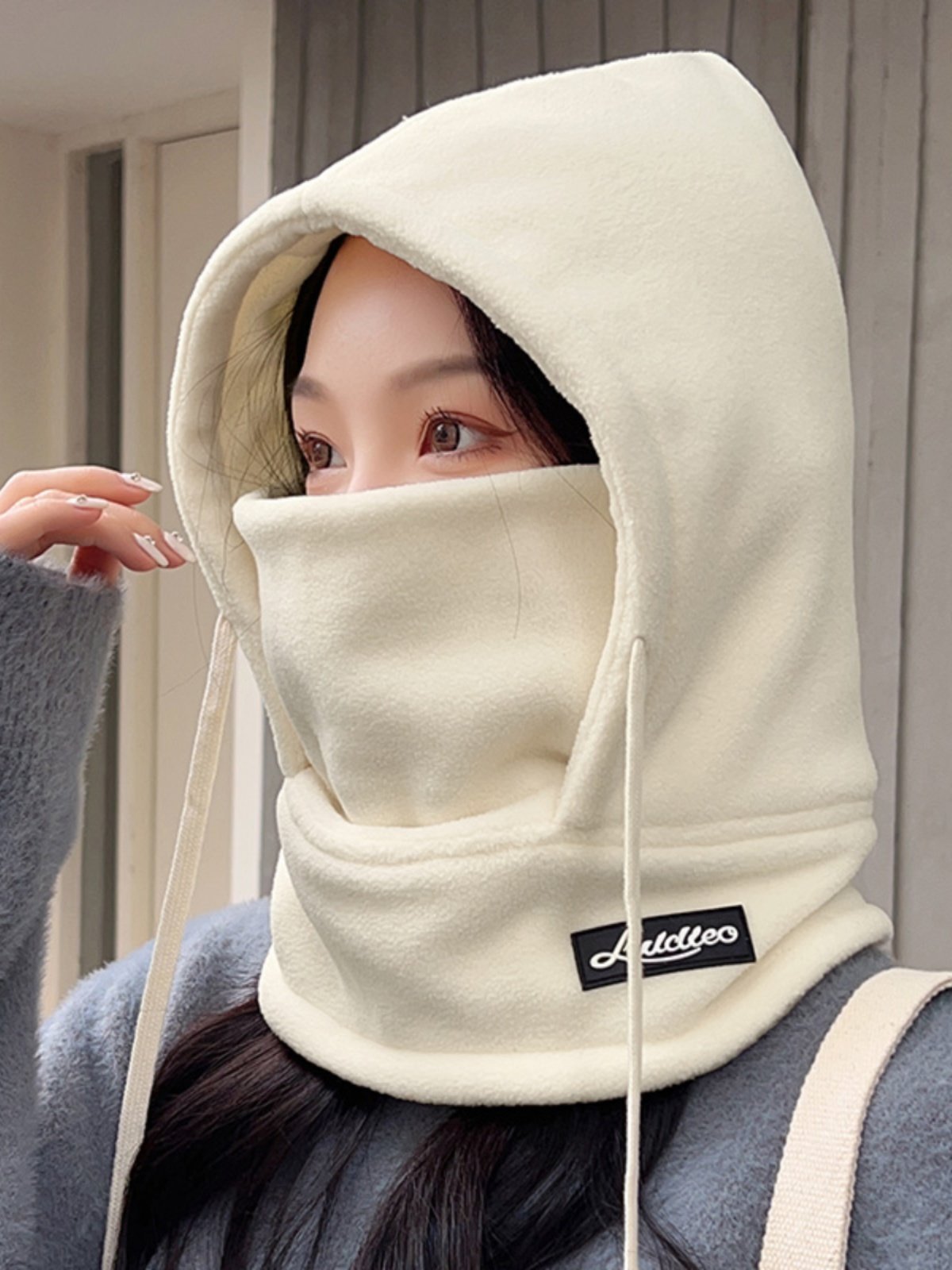 The woman with the hat rides in the winter and winters against the cold and wind-proof hoods