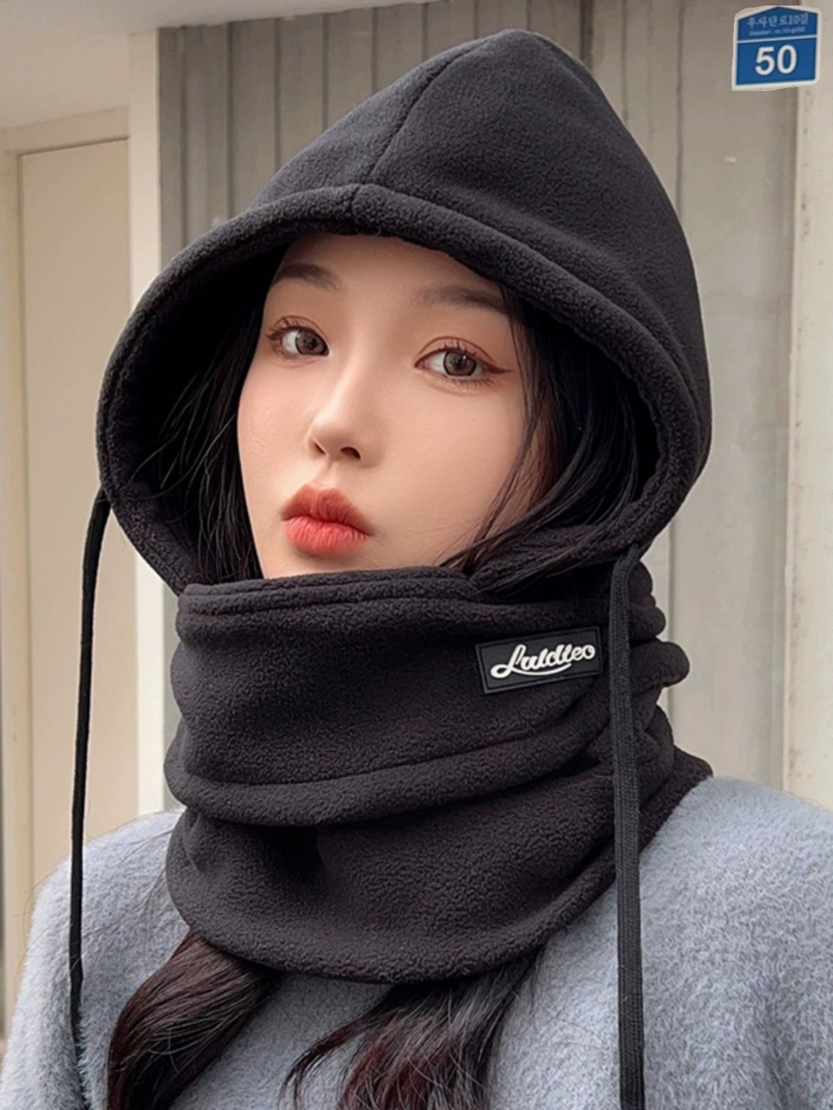 The woman with the hat rides in the winter and winters against the cold and wind-proof hoods