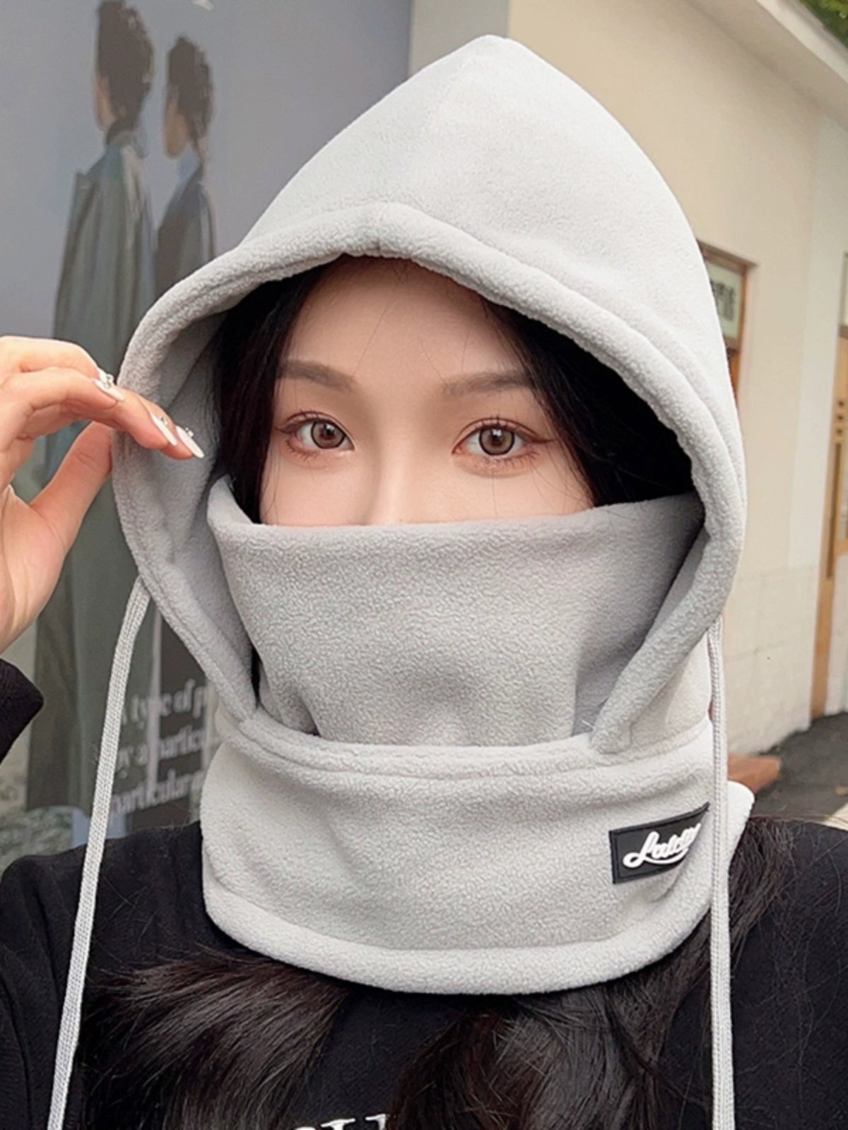 The woman with the hat rides in the winter and winters against the cold and wind-proof hoods