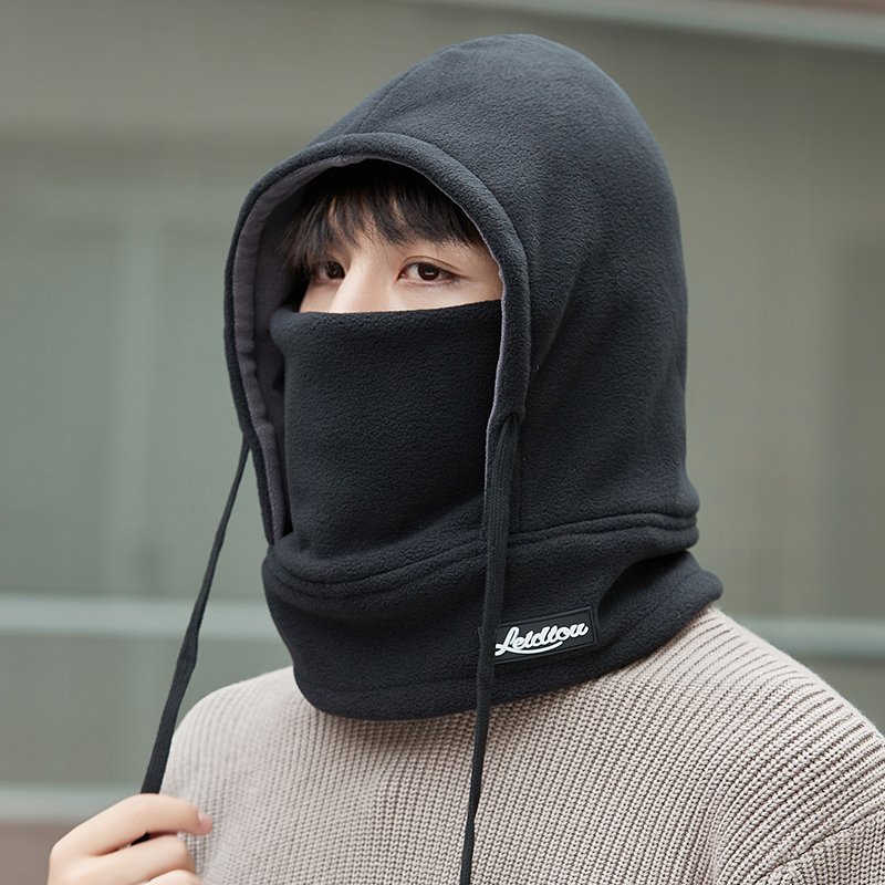 Frozen hat man rides in winter with a thick heated mask to cover his ear and head with a ricket to protect him from the cold