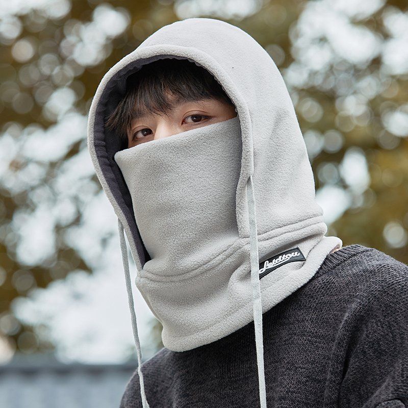 Frozen hat man rides in winter with a thick heated mask to cover his ear and head with a ricket to protect him from the cold