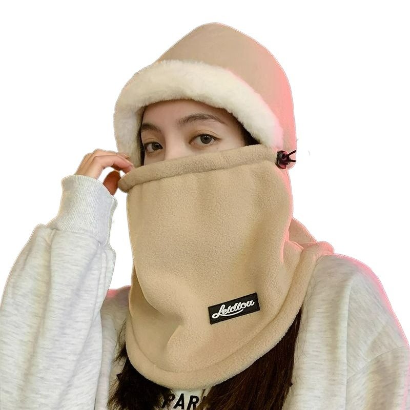 In winter, a woman with a warm head cap rides an electric car around with a decent ski mask and a cold neck scarf