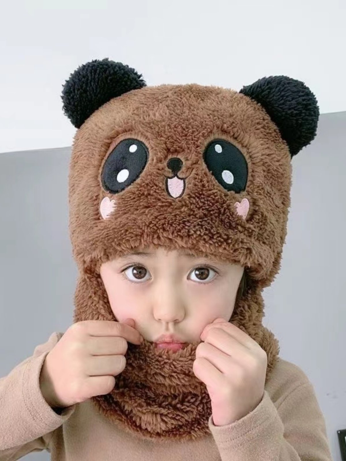 In autumn and winter, the boy and girl with the scarf and the baby with the hood and the hood