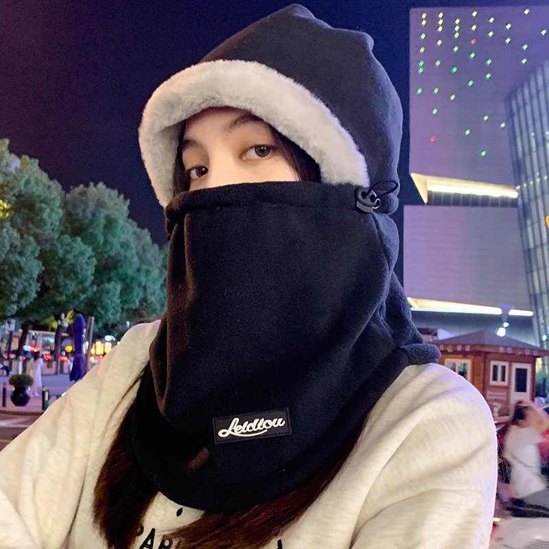 In winter, a woman with a warm head hat rides around a decent electric car skiing and a cold neck scarf