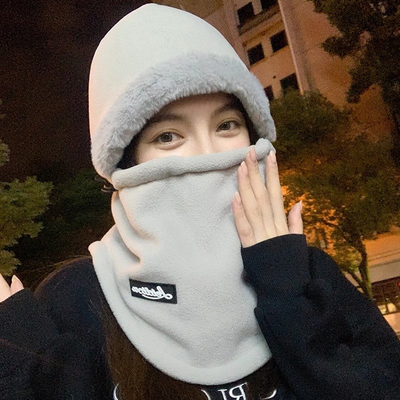In winter, a woman with a warm head hat rides around a decent electric car skiing and a cold neck scarf