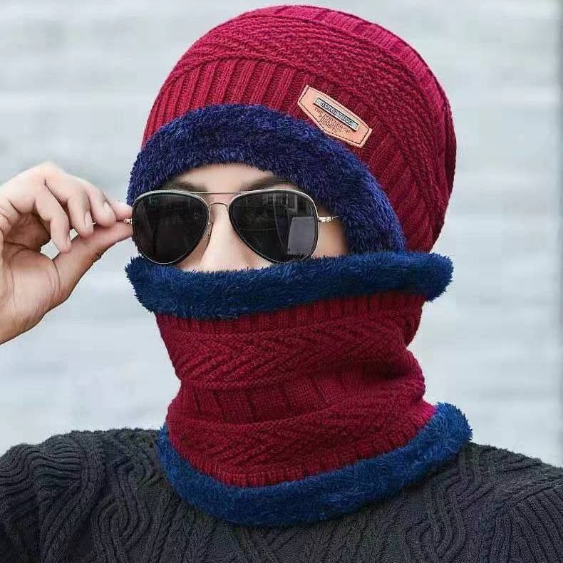 A warm-haired man with a winter knitting cap and a thick wind-proofer set of climbers