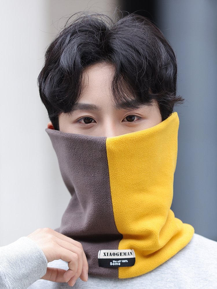 The man with the neck and face is on his way out of the house on a warmer and thicker winter