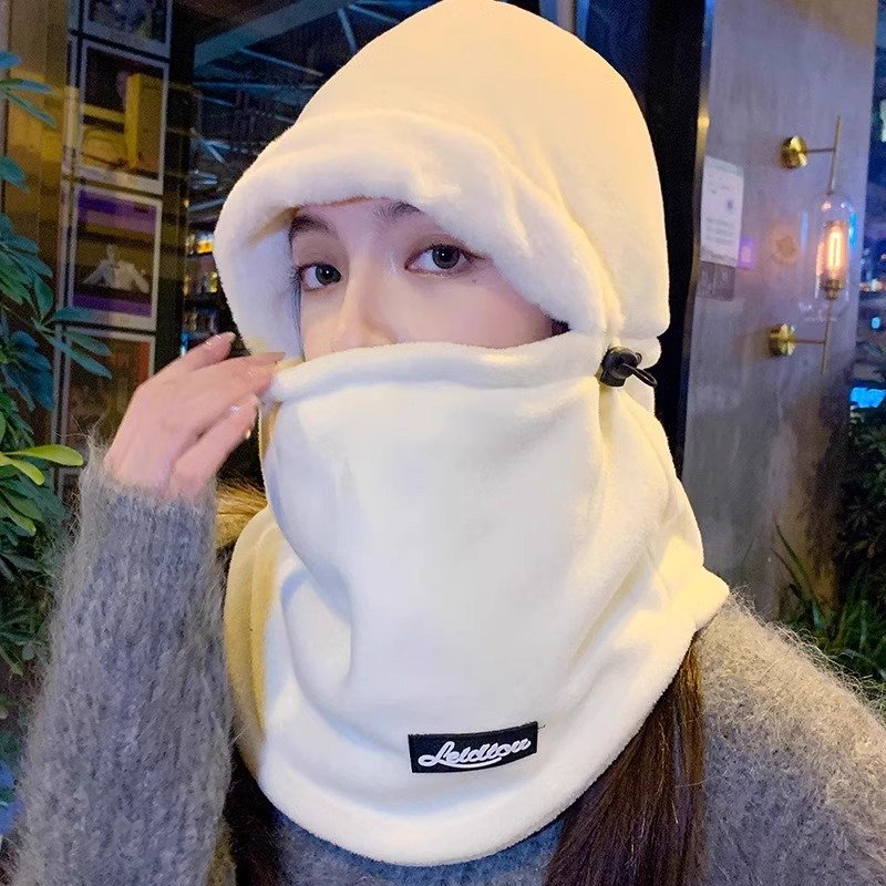 In winter, a woman with a warm head cap rides a decent ski and wind and cold scarf