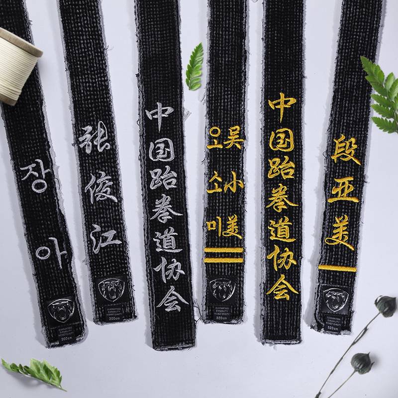A black tape with a black belt and a black coach with a male karate judo