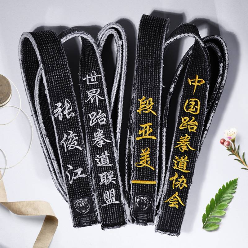 A black tape with a black belt and a black coach with a male karate judo