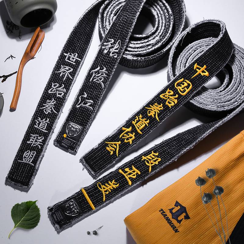 A black tape with a black belt and a black coach with a male karate judo
