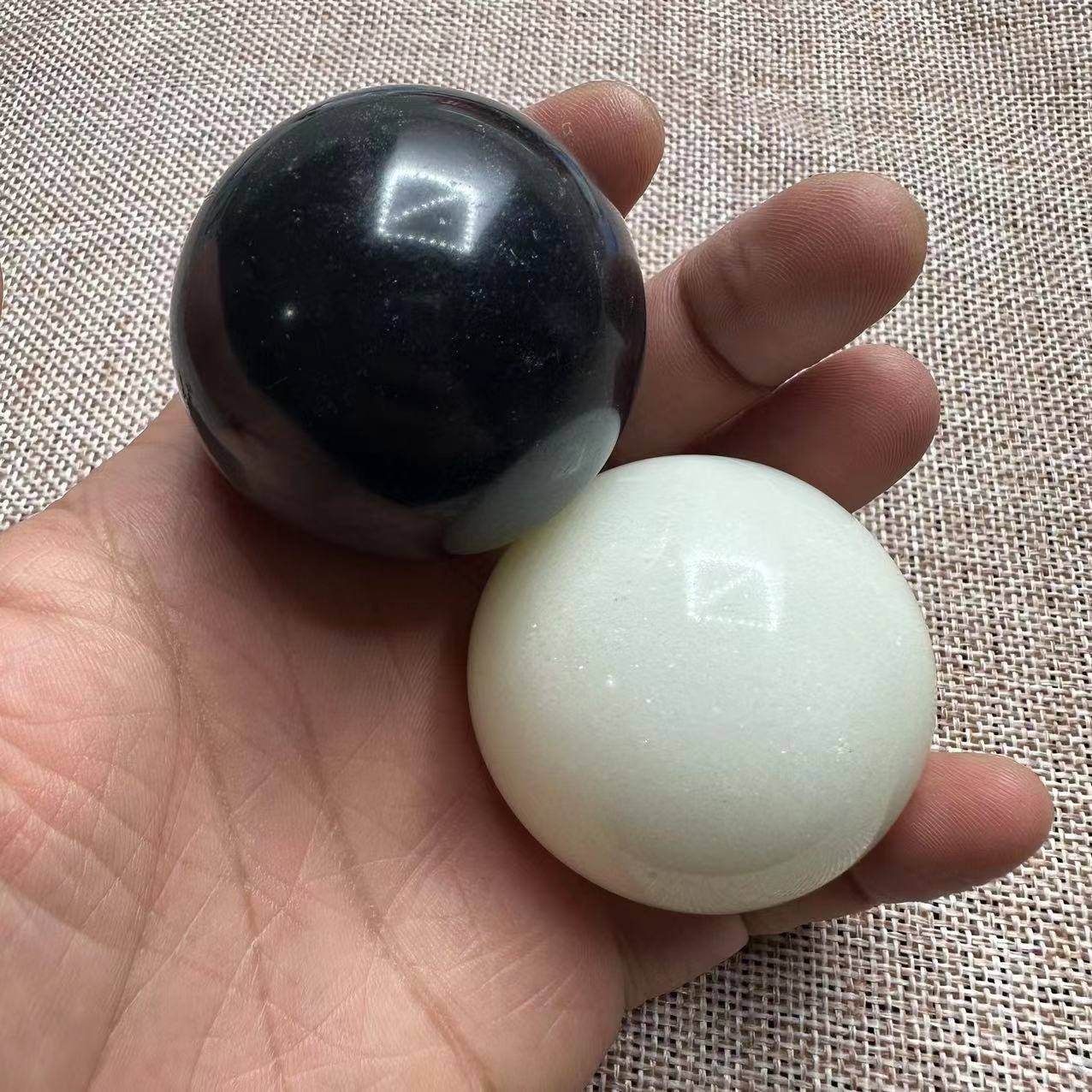 a pair of black stone and white jade, around 46mm