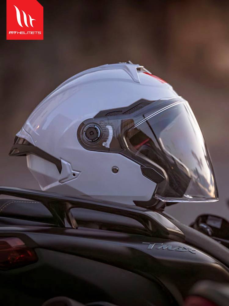 THREE-QUARTERS OF THE NEW MT HELMET, A MAN AND A WOMAN ON A SUMMER MOTORCYCLE