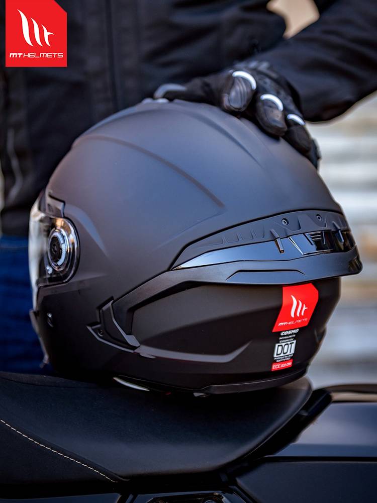 THREE-QUARTERS OF THE NEW MT HELMET, A MAN AND A WOMAN ON A SUMMER MOTORCYCLE