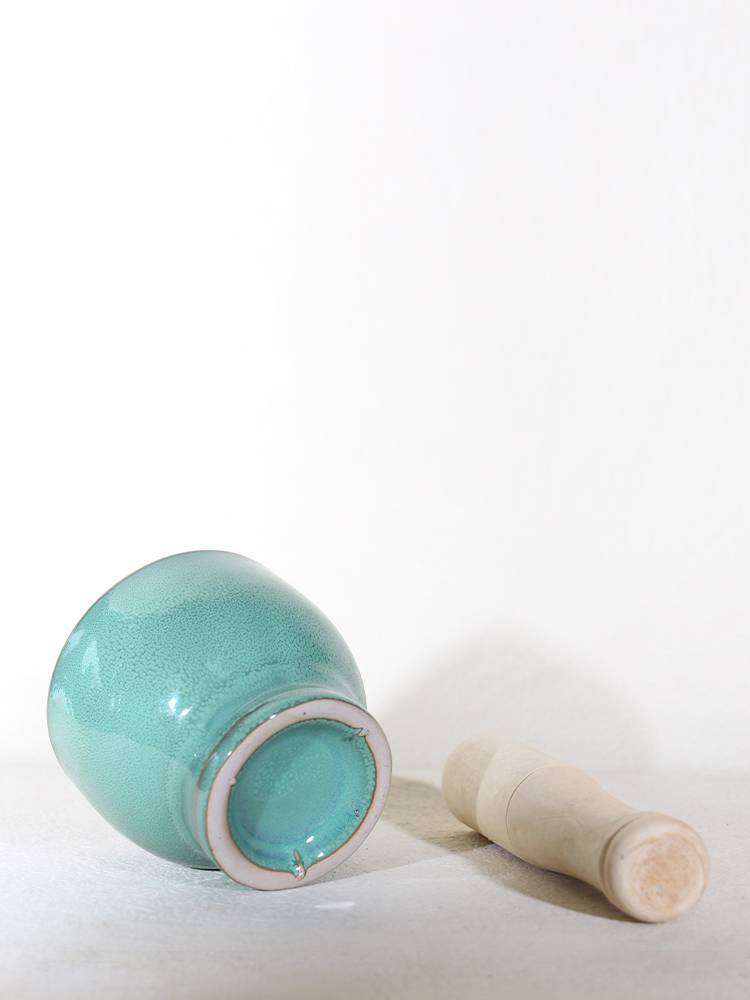 The porcelain garlic mooring grinder crushes the garlic jar with the old-fashioned retro-manufacturing kitchen