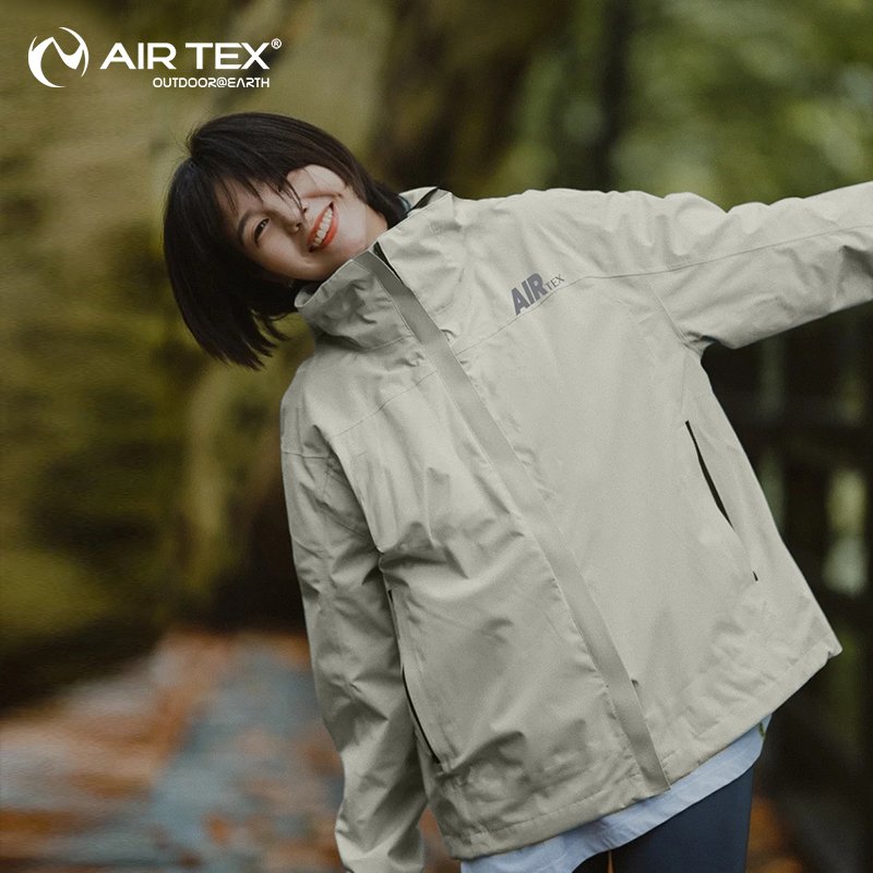 UNDER THE SPOTLIGHT, THE MEN AND WOMEN IN THE T-SHIRTS AND THE WIND AND WATER-PROOF COATS OUTSIDE THE HOUSE IN THE AUTUMN AND WINTER