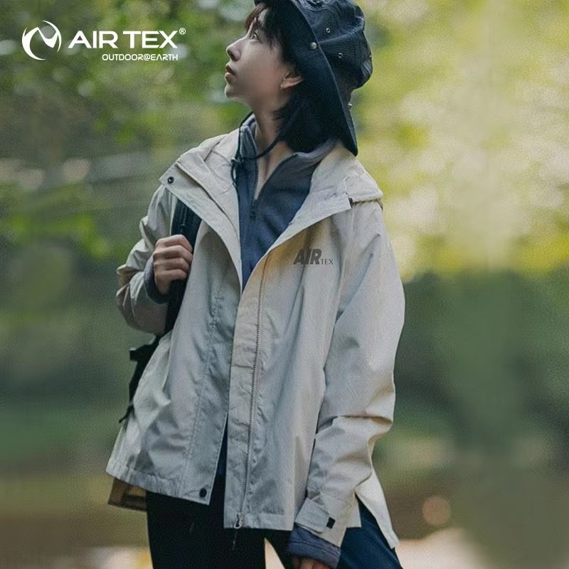 UNDER THE SPOTLIGHT, THE MEN AND WOMEN IN THE T-SHIRTS AND THE WIND AND WATER-PROOF COATS OUTSIDE THE HOUSE IN THE AUTUMN AND WINTER
