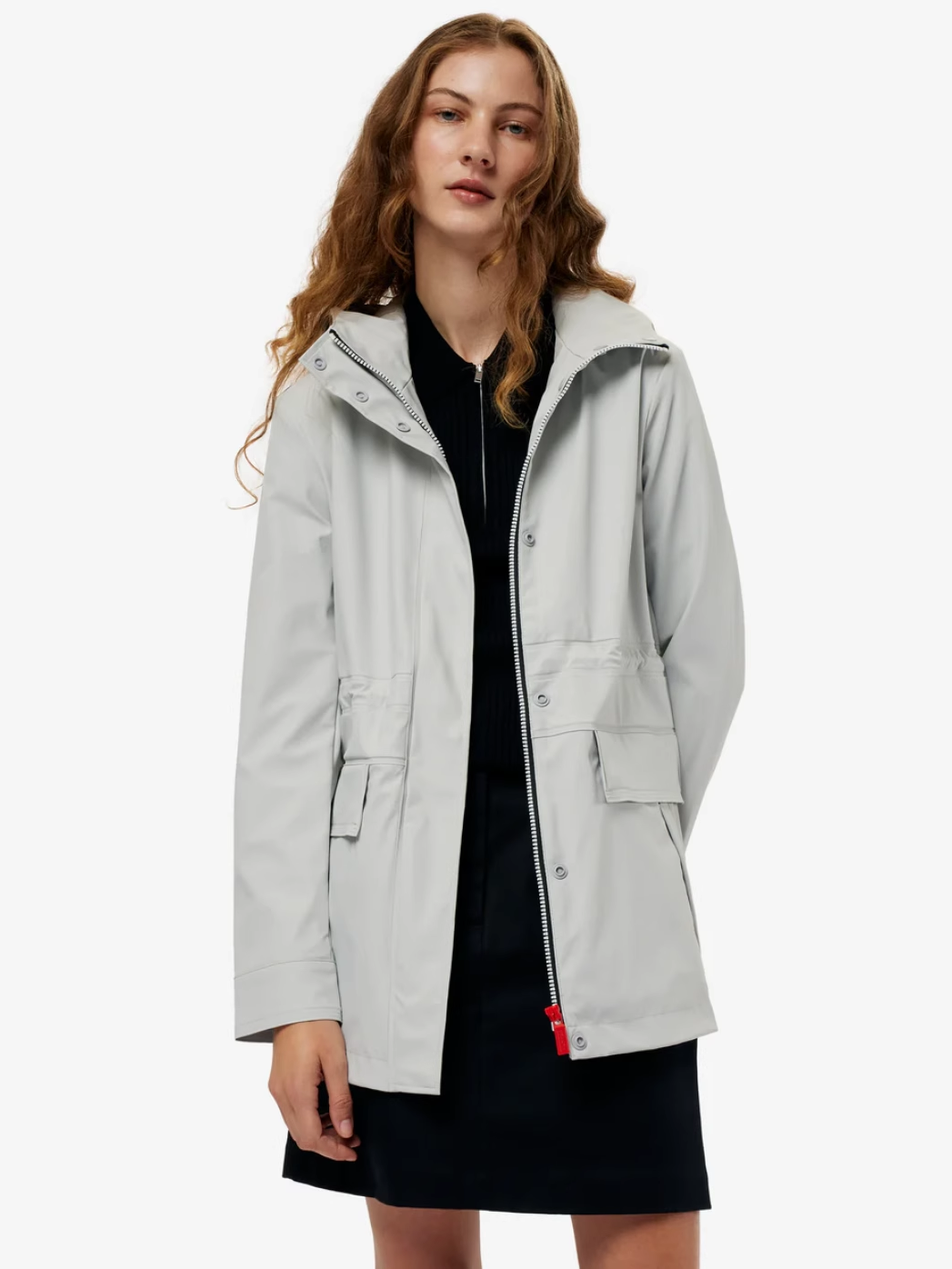 A WOMAN WITH A LONG HAT JACKET AND A RAINCOAT IN AN OUTDOOR HT