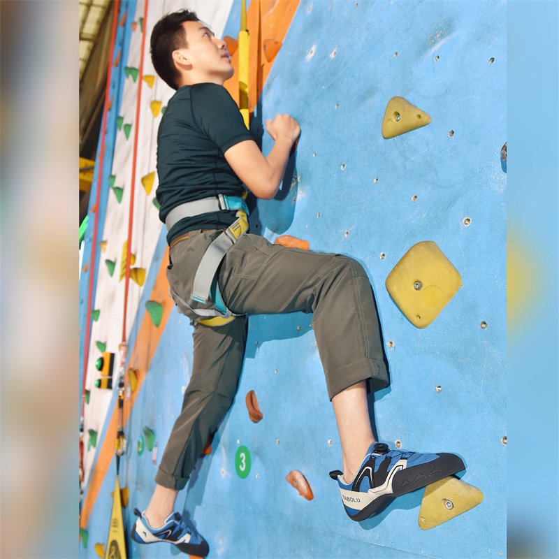 A man and a woman specializing in rock-climbing and climbing outside of their shoes, training in the first stone-crowding room