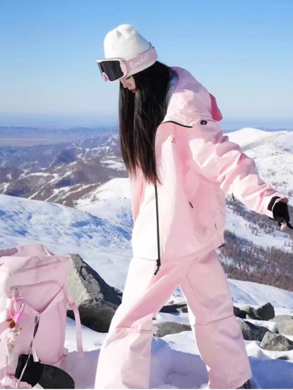 An outdoor ski suit, a man and a woman with a single, loose coat with a pair of ski pants