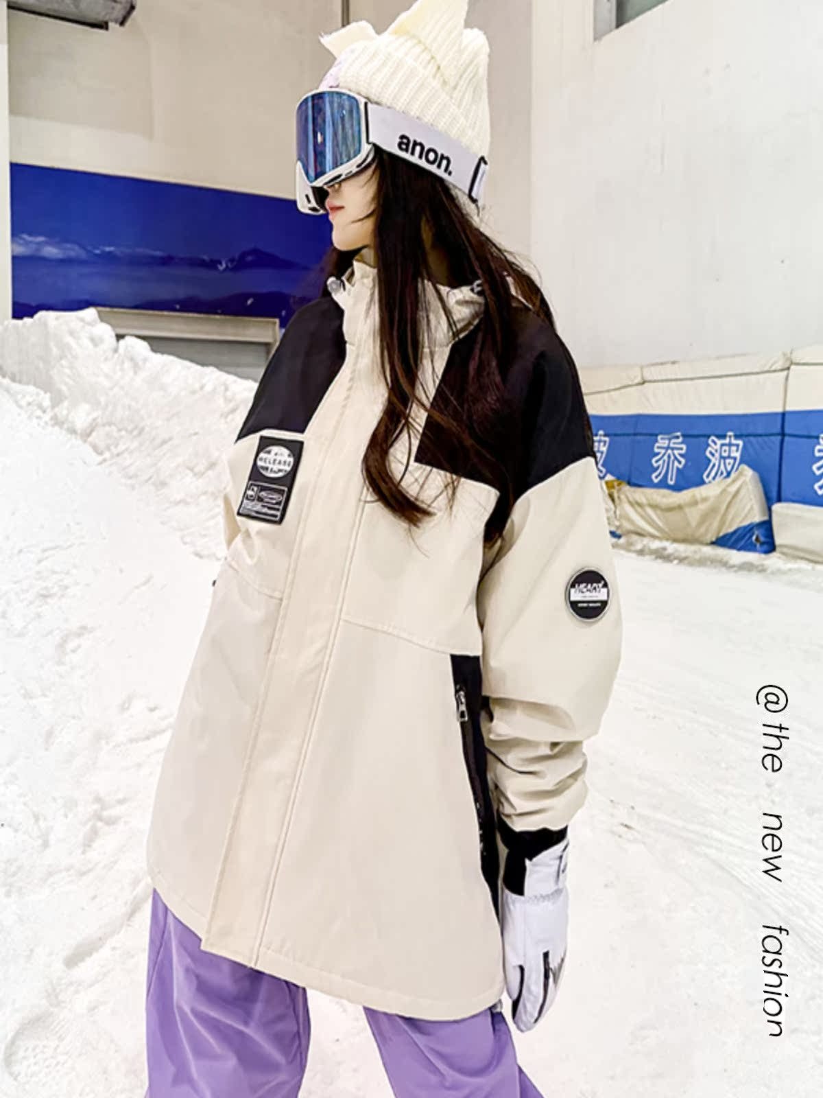 An outdoor ski suit, a man and a woman with a single, loose coat with a pair of ski pants