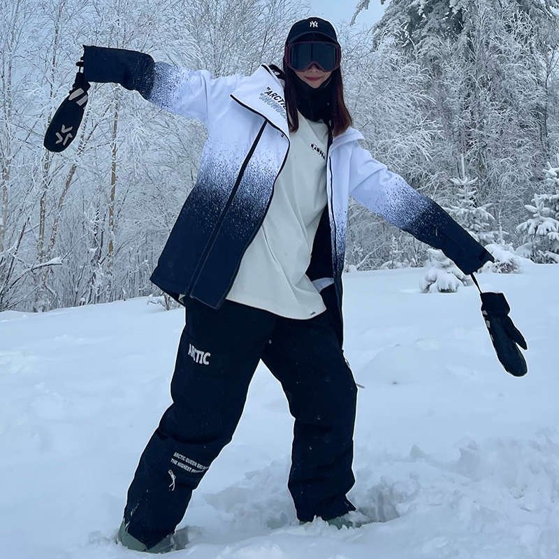 A woman in ski suits with a man on the outside in winter with a warmer and thicker ski pants