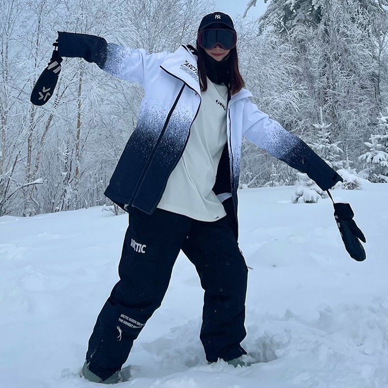 A woman in ski suit with a man in an outdoor winter weather and waterproof and thick ski pants