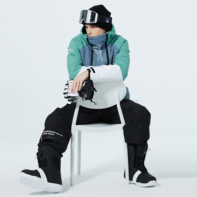 A woman in ski suit with a man in an outdoor winter weather and waterproof and thick ski pants