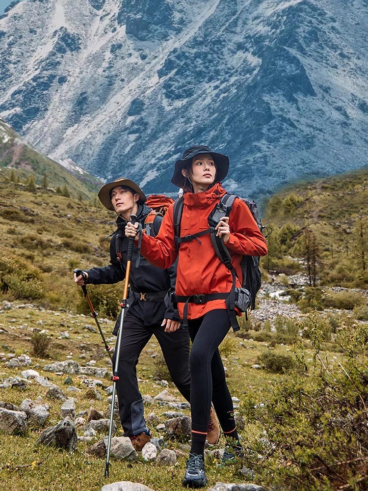 The man with a three-and-a-water-proof, wind-proof coat can be decorated by an outdoor climber