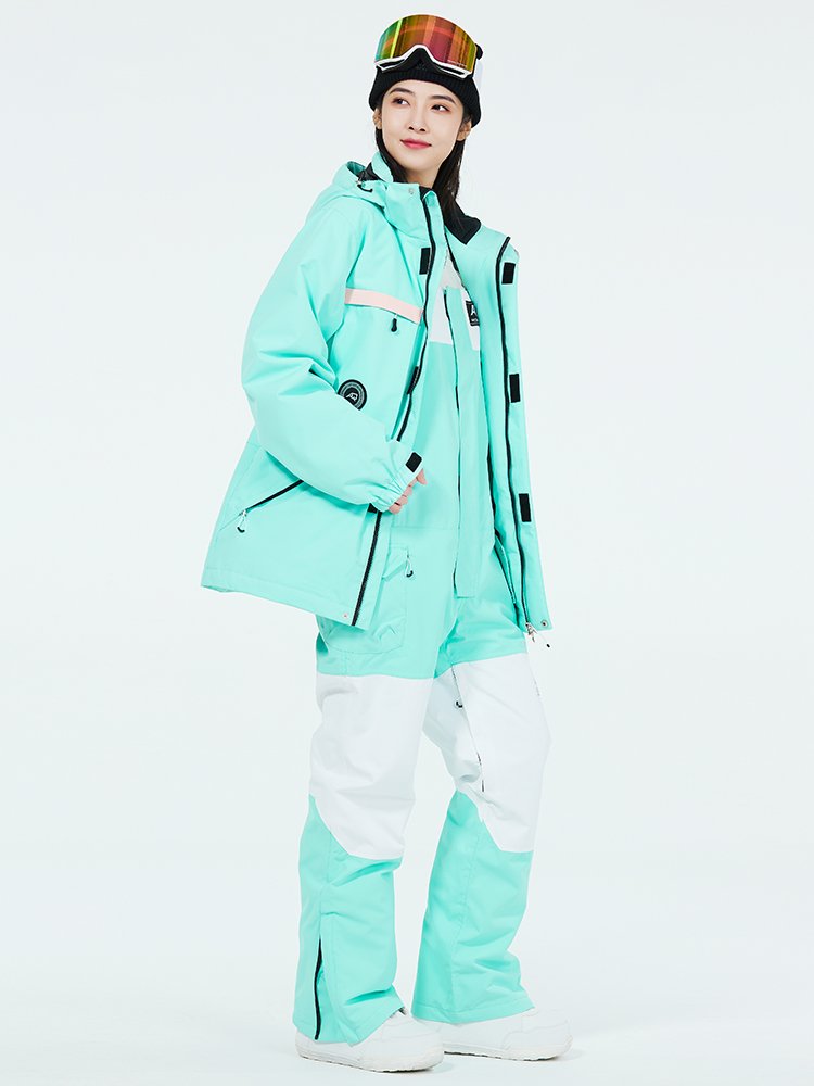 Women in ski suits with men in outdoor weather and waterproof ski pants for winter