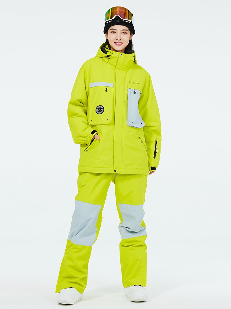 Women in ski suits with men in outdoor weather and waterproof ski pants for winter