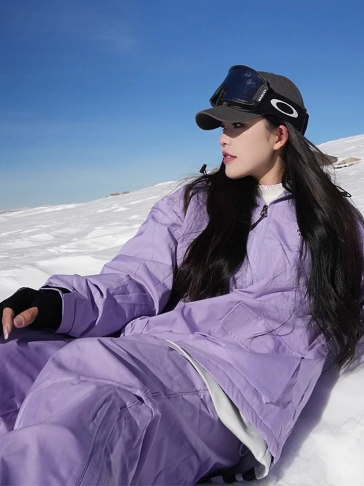 An outdoor ski suit, a man and a woman with a single, loose coat with a pair of ski pants