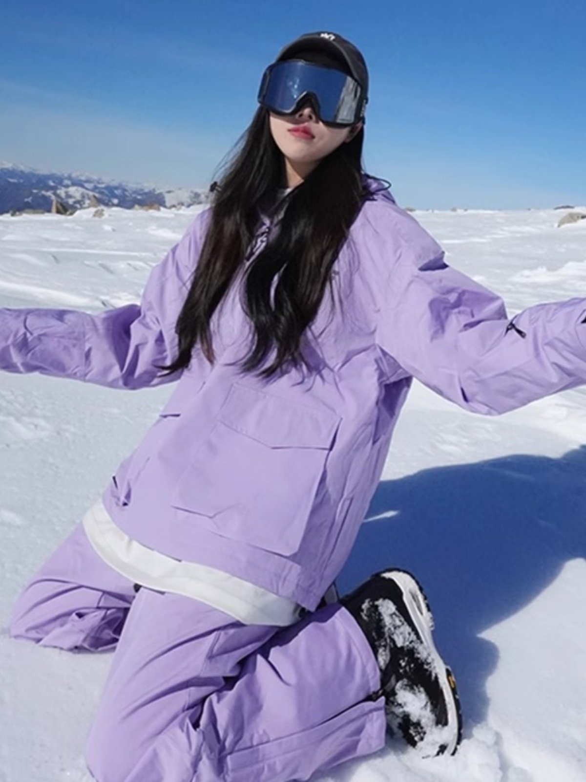 An outdoor ski suit, a man and a woman with a single, loose coat with a pair of ski pants