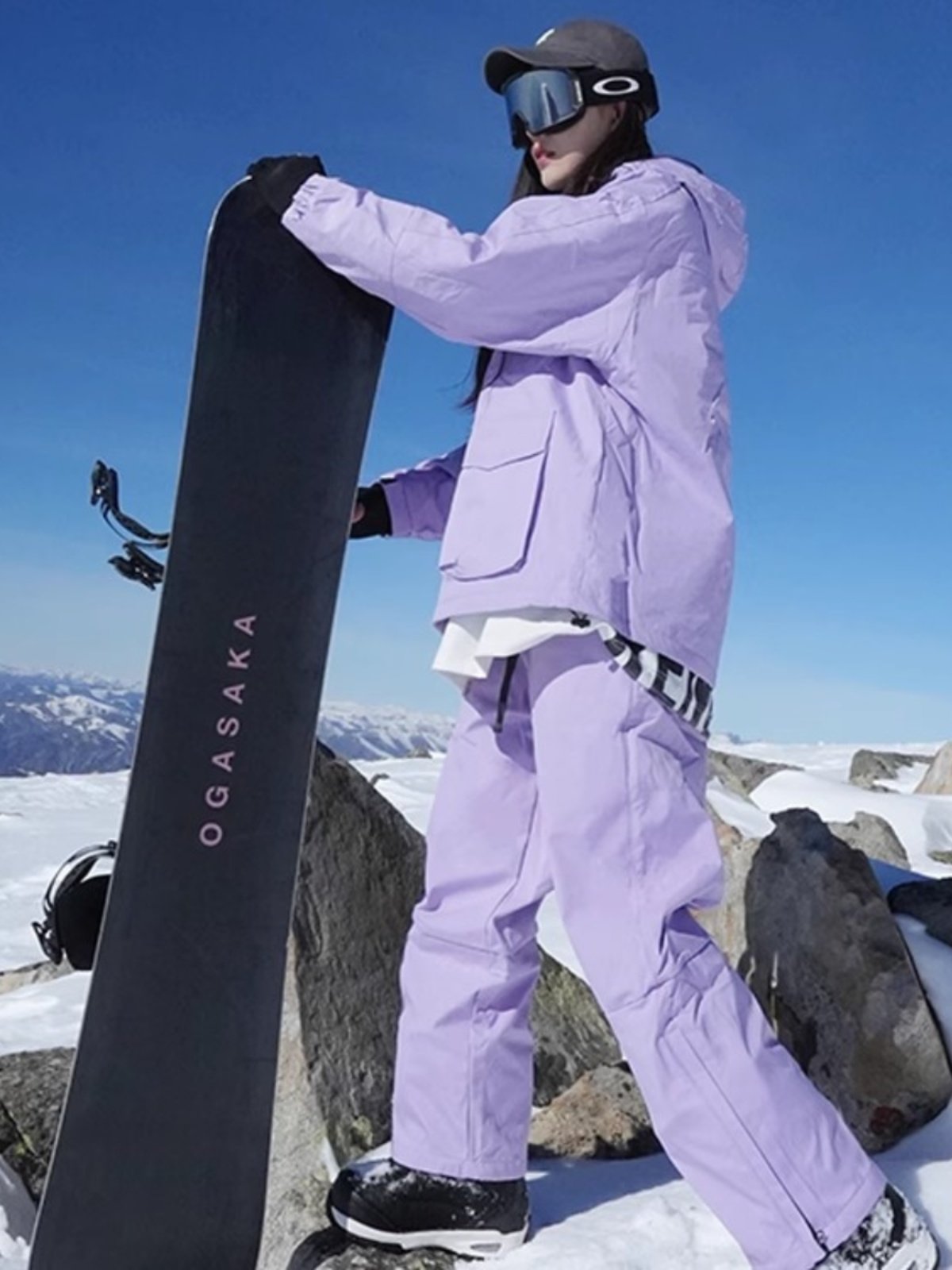 An outdoor ski suit, a man and a woman with a single, loose coat with a pair of ski pants
