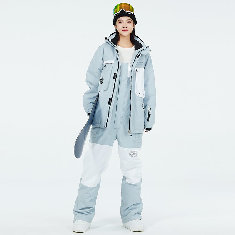 Women in ski suits with men in outdoor weather and waterproof ski pants for winter
