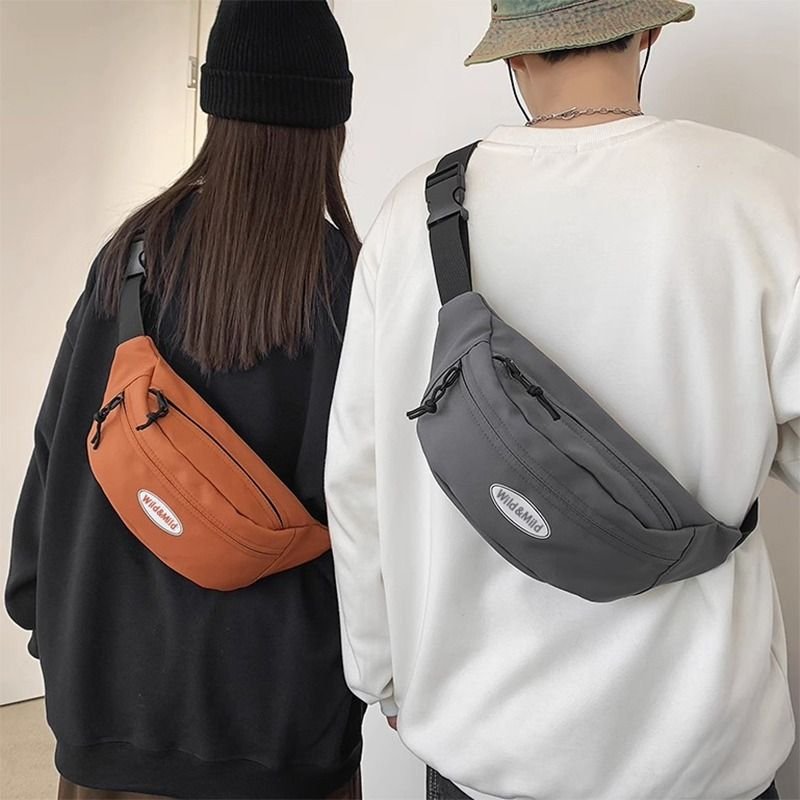 A slashy-packed man's phone rides his waist and hands on a one-shoulder backpack and a one-size-fits-all