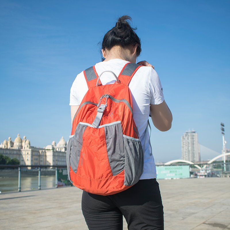 Outdoor light-skinned girls fold their shoulders in the summer and travel with their sport packs to climb